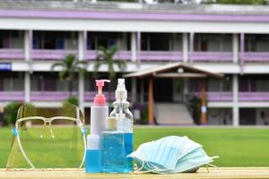 gel désinfectant pour les mains et masques faciaux pour se nettoyer les mains et les porter avant d'entrer pour protéger et prévenir le virus covid-19 ou le coronavirus et les germes. photo