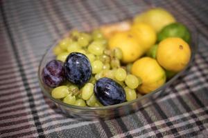 raisin vert prune rouge pomme verte sur plaque sur table photo