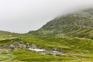 brouillard, nuages, rochers et falaises sur la montagne veslehodn veslehorn, norvège. photo