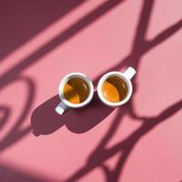 Deux tasses de café expresso vue de dessus avec des ombres dures sur fond coloré photo