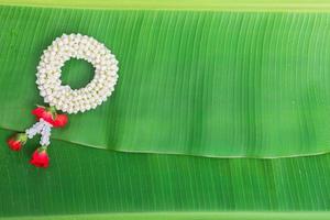 fond de festival de songkran avec guirlande de jasmin sur fond de feuille de bananier vert photo