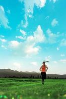 jeune femme asiatique de remise en forme court et fait du jogging une séance d'entraînement en plein air à la campagne le matin pour la santé de son mode de vie. photo