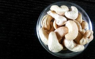 noix de cajou dans le bol en verre sur la table en bois photo