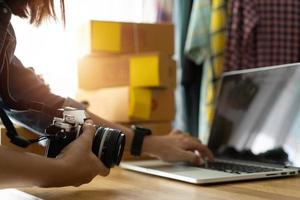 femmes propriétaires d'entreprise travaillant un ordinateur portable vendant en ligne, avec tenir l'appareil photo