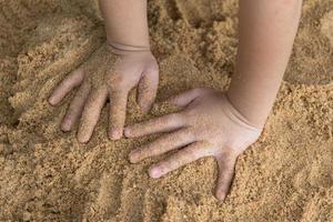 main des enfants sur le sable photo