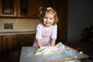 petite fille qui pétrit la pâte photo