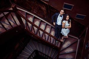 jeune couple à la mode debout dans les escaliers et se serrant les coudes photo