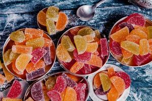 collection de bougies de marmelade colorées. table sucrée avec des bocaux de bonbon. photo