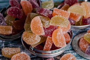 collection de bougies de marmelade colorées. table sucrée avec des bocaux de bonbon. photo