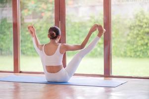 la méditation et les étirements des femmes asiatiques détendent leurs muscles en faisant du yoga dans la chambre photo