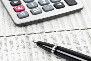 stylo et calculatrice sur le journal financier détaillé du cours des actions photo
