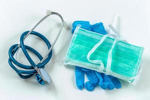 concept d'équipement médical de protection pendant une épidémie de virus - masque chirurgical, lunettes, stéthoscope et gants médicaux. photo