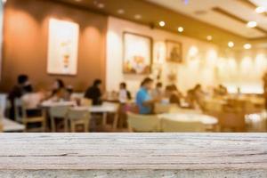dessus de table en bois sur le café-restaurant flou avec arrière-plan flou photo