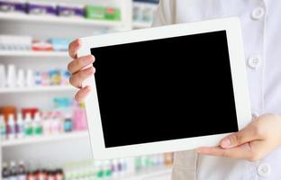 femme pharmacien montre une tablette à la pharmacie photo
