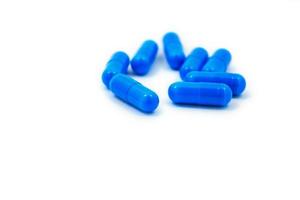 capsules bleues sur fond blanc photo