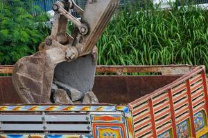 moteur hydraulique d'excavatrice ou camion macro travaillant sur un chantier de construction séparé de la roche et du sol photo