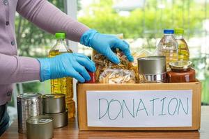 denrées alimentaires pour le don, le stockage et la livraison. divers aliments, pâtes, huile de cuisson et aliments en conserve dans une boîte en carton. photo