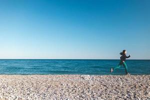 une fille sur un jogging matinal sur la plage photo