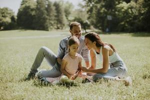 jeune famille heureuse avec une petite fille mignonne s'amusant dans le parc par une journée ensoleillée photo