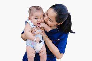 heureux enfant garçon suçant les doigts et regardant la caméra avec une jeune femme embrassant adorable petit garçon isolé sur fond blanc. photo