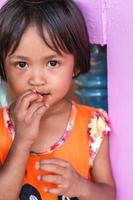 gros plan d'une adorable petite fille regardant la caméra tout en mangeant des collations. photo