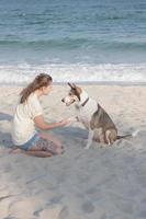 femme jouant avec un chien sur la plage photo