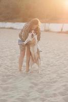 femme jouant avec un chien sur la plage photo