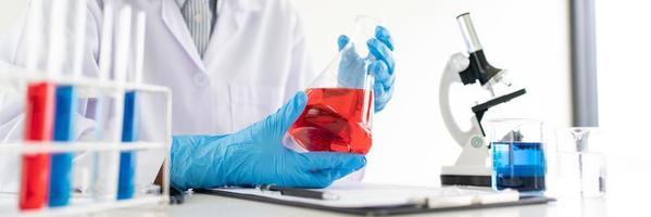 scientifiques faisant des recherches en laboratoire en blouse blanche, gants analysant, regardant un échantillon de tubes à essai, concept de biotechnologie photo