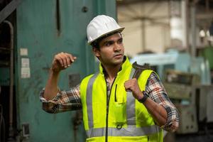 le contremaître ou l'ouvrier travaille sur le site de l'usine pour vérifier la machine ou les produits sur le site. ingénieur ou technicien vérifiant le matériel ou la machine sur l'usine. industriel et usine. photo