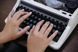 gros plan sur la main des femmes tapant sur la machine à écrire. photo