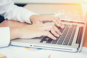 gros plan sur une main de femme d'affaires tapant sur un clavier d'ordinateur portable photo