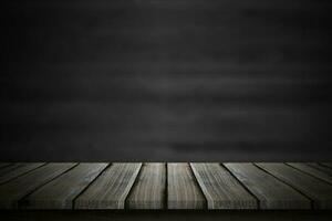 plateau de table en bois vide sur fond de tableau noir flou. photo