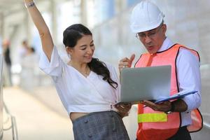 l'ingénieur et la femme d'affaires vérifient le presse-papiers sur le chantier de construction. le concept d'ingénierie, de construction, de vie urbaine et d'avenir. photo