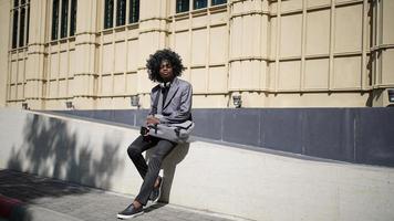 homme afro-américain s'amusant à marcher dans le centre-ville - jeune homme heureux profitant d'un coucher de soleil en plein air - mode de vie de la génération du millénaire et concept d'attitude positive des personnes photo