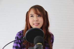 portrait jeune femme chantant au microphone, gros plan tourné. photo