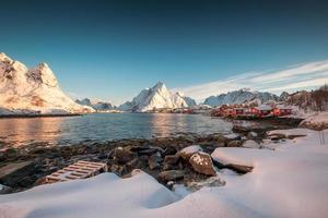 village scandinave dans la chaîne de montagnes enneigées sur le littoral