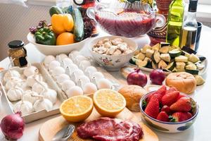 boeuf cru, oeuf avec des légumes sains, fruits préparés à cuire sur la table photo