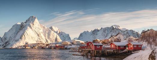village scandinave avec montagne enneigée sur la côte le matin photo