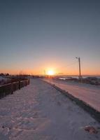 lever du soleil sur le village de reine dans la neige aux îles lofoten photo