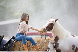 jeune femme avec son cheval dans la lumière du coucher du soleil du soir. photographie en plein air avec une fille mannequin. mode de vie photo