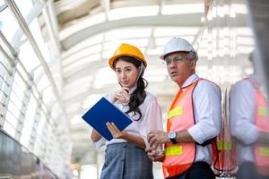 l'ingénieur et les hommes d'affaires remettent cinq contre le bâtiment. le concept d'ingénierie, de construction, de vie urbaine et d'avenir. photo