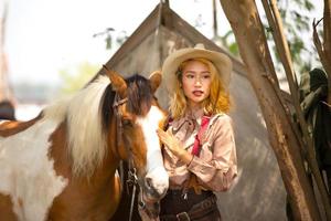 jeune femme avec son cheval dans la lumière du coucher du soleil du soir. photographie en plein air avec une fille mannequin. mode de vie photo