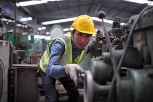 les ingénieurs de maintenance travaillent devant la réparation automatisée des machines cnc sur une liste de contrôle de maintenance sur la ligne de production. photo