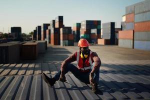 ingénieur ou superviseur vérifiant et contrôlant la boîte de conteneurs de chargement de la cargaison au port. le contremaître contrôle le navire de fret de conteneurs industriels dans l'industrie. concept de transport et de logistique. photo