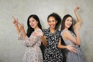 portrait en gros plan d'un mode de vie intérieur de trois jeunes amis amusants qui s'amusent et prétendent des visages. ambiance de fête à la maison. journée internationale de la femme. groupe de trois jeunes femmes heureuses souriantes. génération z photo