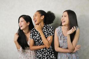 portrait en gros plan d'un mode de vie intérieur de trois jeunes amis amusants qui s'amusent et prétendent des visages. ambiance de fête à la maison. journée internationale de la femme. groupe de trois jeunes femmes heureuses souriantes. génération z photo