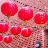 belle lanterne rouge ronde accrochée à la vieille rue traditionnelle, concept du festival du nouvel an lunaire chinois, gros plan. le mot sous-jacent signifie bénédiction. photo