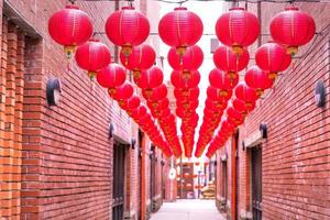 belle lanterne rouge ronde accrochée à la vieille rue traditionnelle, concept du festival du nouvel an lunaire chinois, gros plan. le mot sous-jacent signifie bénédiction. photo