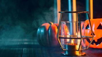 conception de concept de vacances d'halloween de citrouille, bougie, décorations fantasmagoriques avec de la fumée de ton vert autour d'une table en bois sombre, gros plan. photo