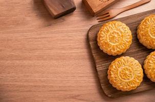 pâtisserie de gâteau de lune fraîchement cuite de forme ronde - moonckae chinois pour le festival de la lune de la mi-automne sur fond en bois et plateau de service, vue de dessus, plat. photo